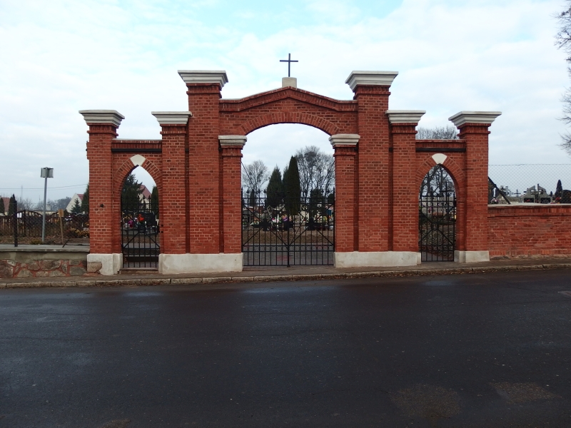 Brama wejściowa na zabytkowy cmentarz. Zbdowana z czerwonej cegły z trzema wejściami, z których środkowe jest wyższe i szersze.